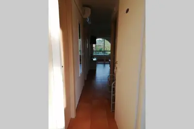 a hallway with a hallway leading into a room at Appartement les pieds dans l'eau 300 m plage - 2 piscines in Linguizzetta