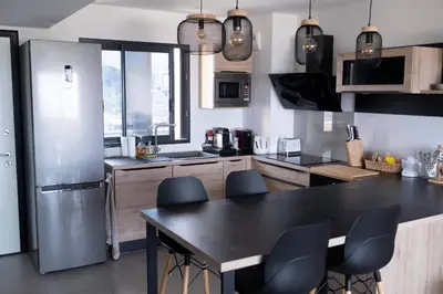 a kitchen with a black table and a refrigerator at Superbe T2 climatisé, proche plage - belle vue mer in Porticcio