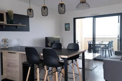 a kitchen with a wooden table and chairs at Superbe T2 climatisé, proche plage - belle vue mer in Porticcio