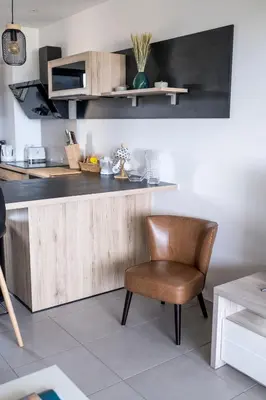 a kitchen with a wooden counter and a chair at Superbe T2 climatisé, proche plage - belle vue mer in Porticcio