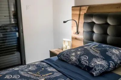 a bed with a blue pillow and a black head board at Superbe T2 climatisé, proche plage - belle vue mer in Porticcio