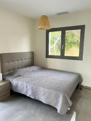a bed in a bedroom with a window at Appartement 140M2 villa cargèse in Cargèse