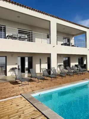 a villa with a swimming pool in front of a house at Appartement 140M2 villa cargèse in Cargèse