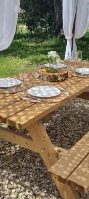 a wooden picnic table with plates and glasses on it at Domaine Authentique de Rose in Porto-Vecchio