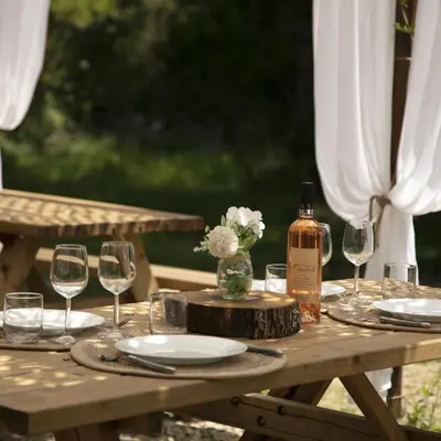 a wooden table with glasses and a bottle of wine at Domaine Authentique de Rose in Porto-Vecchio