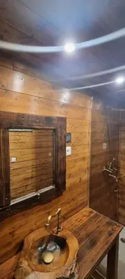 a wooden bathroom with a sink and a mirror at Domaine Authentique de Rose in Porto-Vecchio