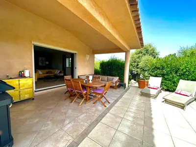 a patio with a table and chairs and a kitchen at villa Filao Sainte Lucie de Porto vecchio in Sainte-Lucie de Porto-Vecchio
