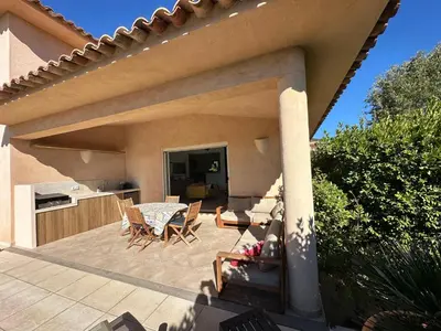 a patio with a table and chairs on a house at villa Filao Sainte Lucie de Porto vecchio in Sainte-Lucie de Porto-Vecchio