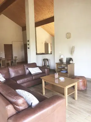 a living room with leather couches and a table at Villa familiale entre mer et montagne Corse in Soccia