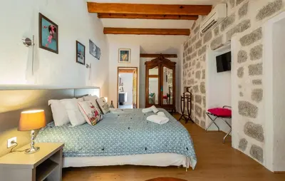 a bedroom with a bed and a stone wall at Auberge U n'Antru Versu in San-Gavino-di-Carbini