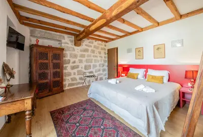 a bedroom with a large bed in a room with wooden ceilings at Auberge U n'Antru Versu in San-Gavino-di-Carbini