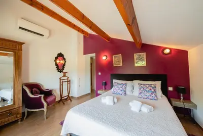 a bedroom with a bed and a red wall at Auberge U n'Antru Versu in San-Gavino-di-Carbini