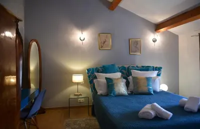 a bedroom with a blue bed with pillows at Auberge U n'Antru Versu in San-Gavino-di-Carbini