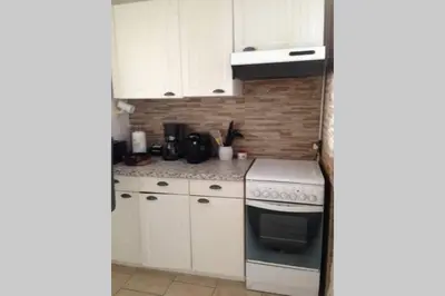 a kitchen with white cabinets and a stove top oven at T2 Sanguinaires calme et cosy, entre mer et maquis in Ajaccio