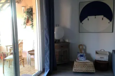 a room with a door open to a room with a table at T2 Sanguinaires calme et cosy, entre mer et maquis in Ajaccio