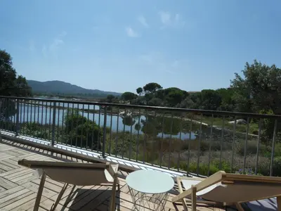 a balcony with chairs and a view of the water at Appartement F2 Porto Vecchio vue sur les salines in Porto-Vecchio