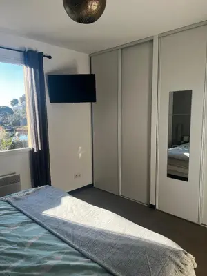 a bedroom with a bed and a large window at Appartement F2 Porto Vecchio vue sur les salines in Porto-Vecchio