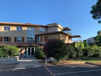 a building with a parking lot in front of it at Appartement F2 Porto Vecchio vue sur les salines in Porto-Vecchio