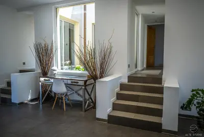 a hallway with stairs and a table with plants at Casa Lagone - Villa Luxe avec Piscine et Superbe Vue in Cargèse
