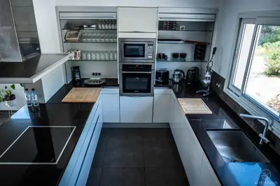 a small kitchen with white cabinets and a window at Casa Lagone - Villa Luxe avec Piscine et Superbe Vue in Cargèse