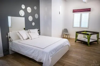 a bedroom with a bed with white sheets and a table at Casa Lagone - Villa Luxe avec Piscine et Superbe Vue in Cargèse