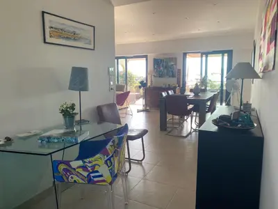 a living room with a table and a dining room at VUE MAGNIFIQUE SUR BAIE AJACCIO in Porticcio