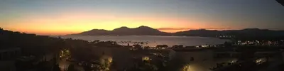 a sunset over a city with mountains in the background at VUE MAGNIFIQUE SUR BAIE AJACCIO in Porticcio