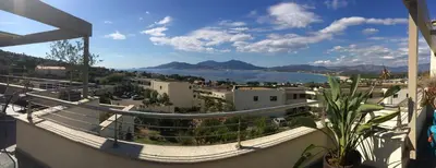 a balcony with a view of a city and water at VUE MAGNIFIQUE SUR BAIE AJACCIO in Porticcio