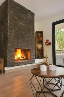 a living room with a fireplace and a table at Casa San-Ghjuvà in Feliceto