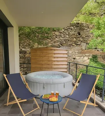 two chairs and a hot tub on a patio at Casa San-Ghjuvà in Feliceto