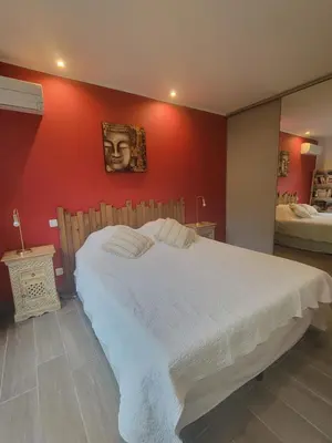 a bedroom with a large white bed with a red wall at Casa San-Ghjuvà in Feliceto