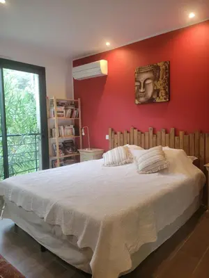 a bedroom with a large bed with a red wall at Casa San-Ghjuvà in Feliceto