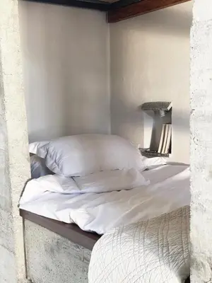 a bed with white sheets and pillows on it at A Casa di Santa Giulia in Porto-Vecchio