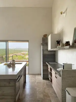 a kitchen with a sink and a large window at A Casa di Santa Giulia in Porto-Vecchio