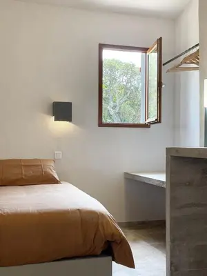 a bedroom with a bed and a window and a tub at A Casa di Santa Giulia in Porto-Vecchio