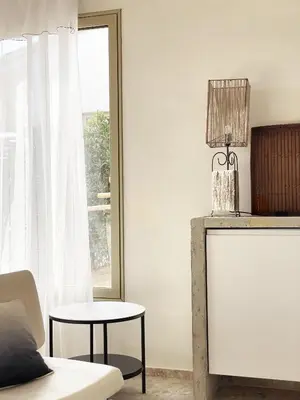 a living room with a table and a mirror at A Casa di Santa Giulia in Porto-Vecchio