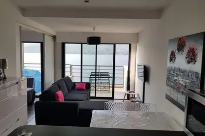 a living room with a couch and a table at Appartement T2 terrasse vue mer à 180 in Propriano