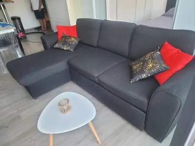 a black couch with pillows and a table in a living room at Appartement T2 terrasse vue mer à 180 in Propriano