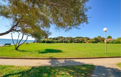 a park with a tree and a street light at 1 Bedroom Amazing Apartment In Prunete in Prunete