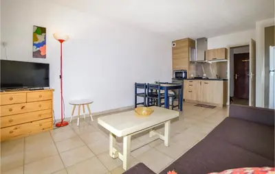 a living room with a table and a kitchen at 1 Bedroom Amazing Apartment In Prunete in Prunete