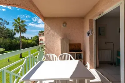 a balcony with a white table and chairs on a patio at Arinella in San-Nicolao