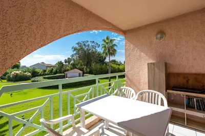 a patio with a white table and chairs on a balcony at Arinella in San-Nicolao