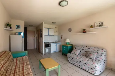 a living room with a couch and a kitchen at Arinella in San-Nicolao