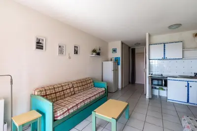 a living room with a couch and a kitchen at Arinella in San-Nicolao