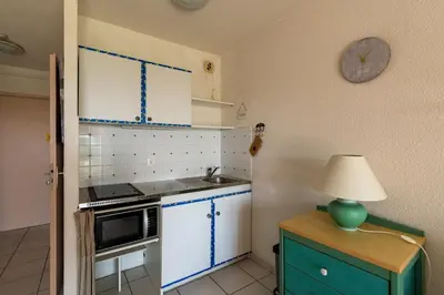 a kitchen with blue cabinets and a clock on the wall at Arinella in San-Nicolao