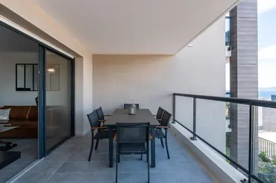 a dining room with a table and chairs on a balcony at Les Rivages De Stagnola - Vue Mer et Plages à Pied in Pietrosella