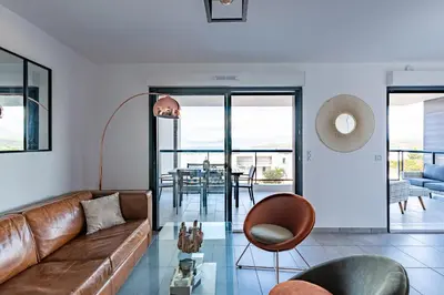 a living room with a couch and a table at Les Rivages De Stagnola - Vue Mer et Plages à Pied in Pietrosella