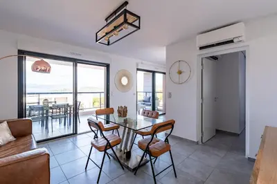 a living room with a table and chairs at Les Rivages De Stagnola - Vue Mer et Plages à Pied in Pietrosella