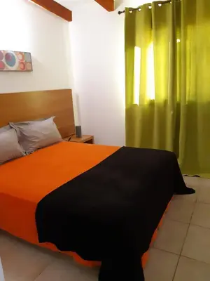a bedroom with a large bed with green curtains at Residences La Tonnara in Bonifacio