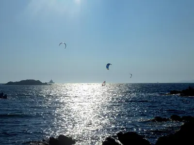 two people flying kites over the water on the beach at Residences La Tonnara in Bonifacio